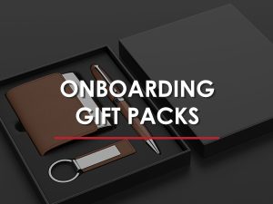 A box of onboarding gifts, including a pen, wallet, and keychain.