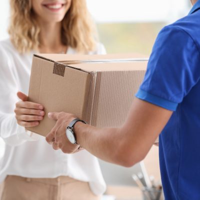 A delivery man handing a package to a customer which is sealed pack.